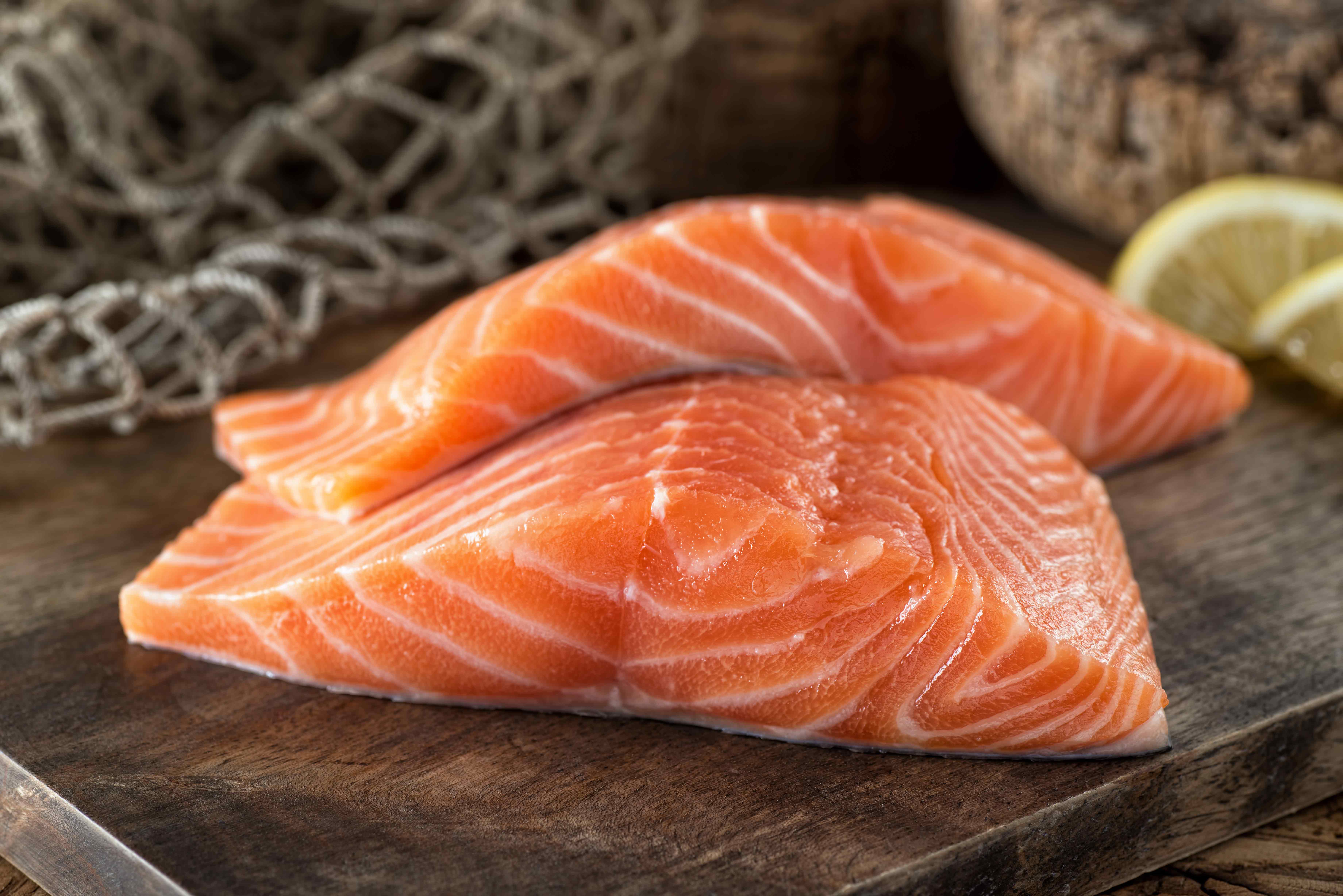 Raw salmon on a wooden plank.